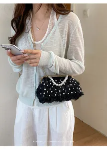 Vue détaillée du sac pochette femme noir floral en perles avec design de sangle à chaîne.