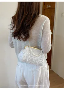 Vue détaillée du sac pochette femme fleurs perles, élégant sac bandoulière chaîne dorée.