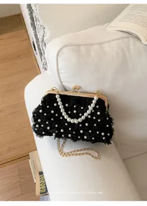 Pochette de soirée noire à fleurs avec poignée en perles et détail de chaîne dorée.