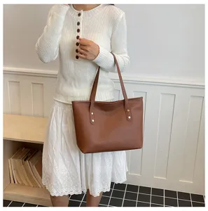 Detalle de bolso tote de cuero marrón elegante, mostrando textura premium y herrajes muy estilosos.