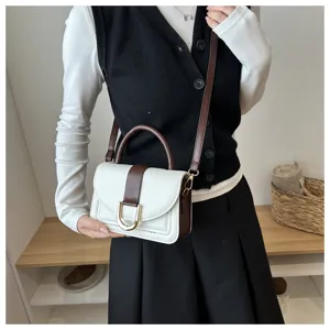 Vista dettagliata del design bicolore bianco e marrone di questa elegante borsa da donna.