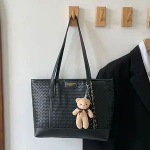 Elegante borsa tote nera in pelle intrecciata con ciondolo orsetto, pratica borsa a spalla