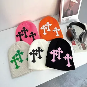Gros plan de bonnet en tricot avec des patchs de croix gothiques de couleurs vibrantes.