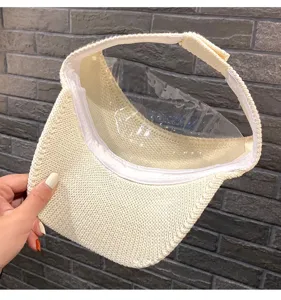 Sombrero de visera solar abierto de mimbre beige con pantalla de plástico transparente.