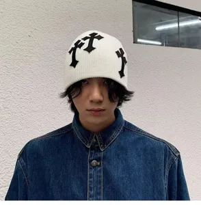 Bonnet en tricot blanc unisexe avec patchs croix noires, style streetwear sombre.