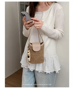 Vista detallada de un mini bolso bandolera trenzado de estilo coreano con colgante.