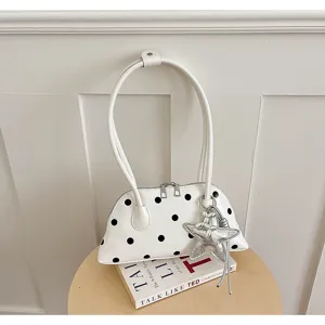Witte schoudertas met zwarte stippen en zilveren sterhanger, minimalistische handtas elegant.