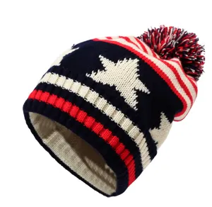 Gedetailleerd overzicht van de winter gebreide muts met sterren patroon en pompon.