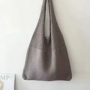 Graue gestrickte Umhängetasche Detail, lässiger ästhetischer Shopper mit Lochmuster Textur.