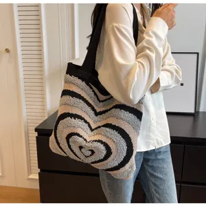 Primo piano della borsa a tracolla in maglia elegante con un motivo a cuori di tendenza.