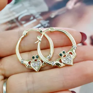 Detailaufnahme goldenen Claddagh Herz-Creolen mit Zirkonia-Steinen und grüner Krone.