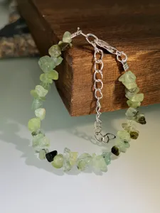 Bracciale di pietre preziose in cristallo verde irregolare con catena di estensione argentata.