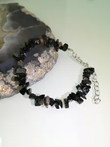 Bracciale in pietra naturale nera irregolare con catena di estensione, vista dettaglio.