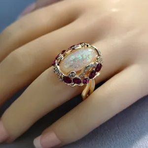 Anello in oro con opale esagerato e pietre preziose rosse e trasparenti per la moda donna.