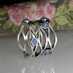 Vintage antique silver interlaced hollow ring featuring blue opal stones, detailed close-up view.
