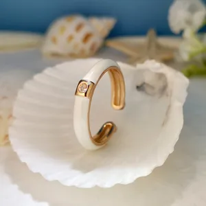 Primo piano dell'anello aperto elegante con smalto bianco e zircone brillante, gioiello.