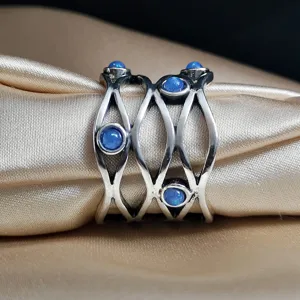 Detailed shot of a vintage Thai silver wide hollow interwoven ring featuring blue opal stones.
