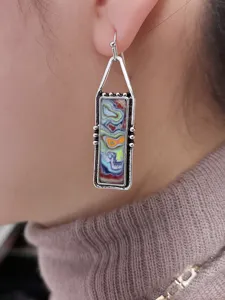 Dettaglio orecchini pendenti boho colorati, gioielli da orecchio artigianali in stile bohemian chic.