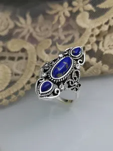 Primo piano dell'anello vintage in argento filigranato con lapislazzuli e dettagli di cristalli.