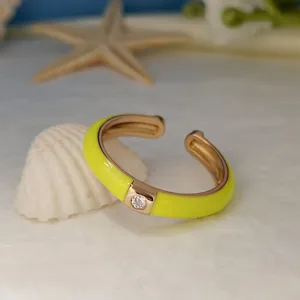 Primo piano dettagliato di anello aperto smaltato giallo minimalista con zircone brillante.