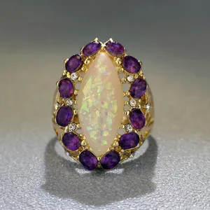Anello dorato vintage con opale centrale a marquise e pietre viola di cristallo molto lucido.