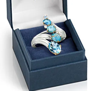 Anello elegante a forma di onda con più pietre preziose blu in una confezione regalo blu