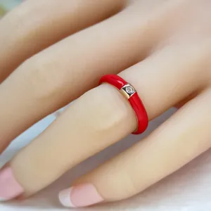 Anello placcato in oro con smalto rosso brillante e un dettaglio di zircone brillante.