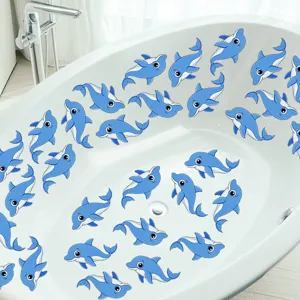 Detailed view of cute blue dolphin anti slip stickers arranged inside a clean white bathtub.