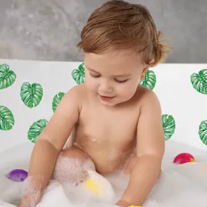Close-up detail of green monstera leaf anti-slip bathtub stickers used in a child bath scene.