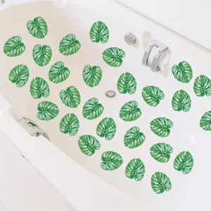 Detailed view of green monstera leaf anti slip bathtub stickers installed inside a white tub.