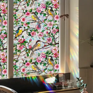 Detailed view of static window film featuring colorful flowers and birds, rainbow light effect.
