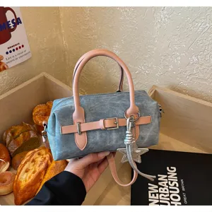 Denim bowling shoulder bag with pink leather handles and star charm detail, stylish daily purse.