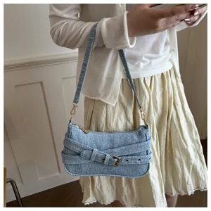 Gedetailleerd overzicht van de stijlvolle denim schoudertas met een unieke gespsluiting.
