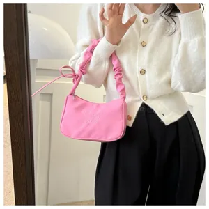 Vista dettagliata della borsa a spalla rosa in nylon plissettato con ricamo di farfalla.