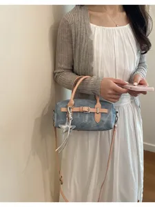 Detailed view of vintage denim pillow shoulder bag with leather straps and chic star charm.