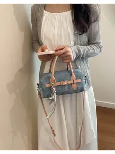 Vintage style blue barrel crossbody bag with pink straps and star pendant in detailed view.