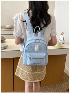 Light blue starry backpack with cute plush bunny patch, stylish casual school bag for women.