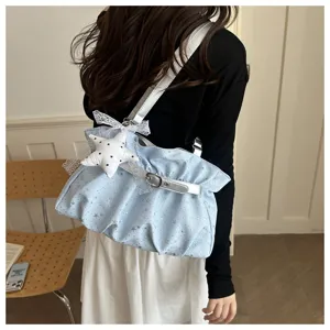 Detailed view of light blue ruffled shoulder bag with silver buckle and star pendant.