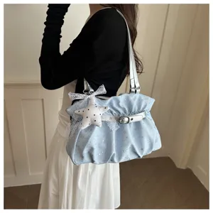 Close-up view of light blue ruched shoulder bag featuring silver strap and cute star plush charm.