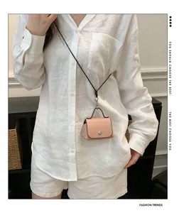 Detailopname van een mini roze lederen tas met zwart koord, zeer stijlvol accessoire.