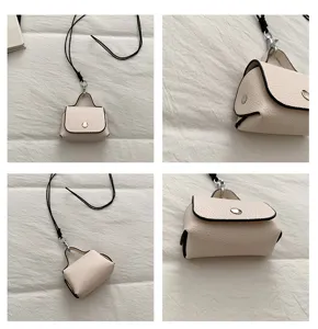 Gedetailleerd overzicht van een mini beige tas met zwarte band en drukknoop, minimalistisch.