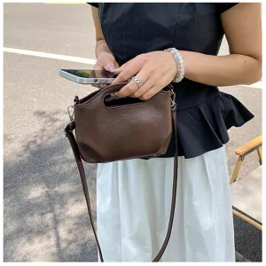 Vue détaillée du sac à bandoulière rétro marron pour femme avec poignée et sangle.