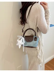 Koreanischer Denim Mini Umhängetasche mit braunem Leder und Stern Anhänger Detail.