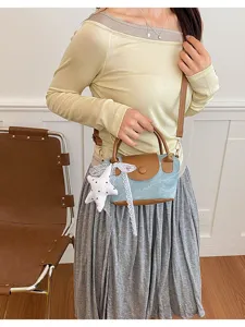 Koreanische Jeans Handtasche mit braunem Lederbesatz, Stern Anhänger und Schulterriemen.