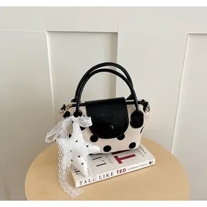Detailaufnahme der koreanischen Pünktchen Handtasche mit schwarzer Klappe und Spitzenstern.