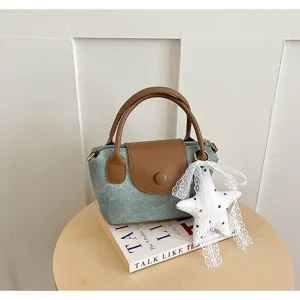 Detailansicht einer trendigen koreanischen Denim Leder Umhängetasche mit Sternanhänger.