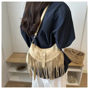 Detail view of the retro fringe suede shoulder bag featuring long tassels and metal hardware.