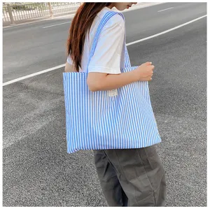 Detailansicht der blau-weißen gestreiften Canvas-Tasche, ideal für das tägliche Pendeln.