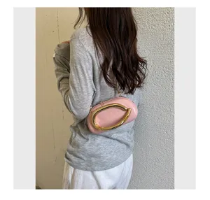 Stylish pink shoulder bag with unique gold metallic handle detail for women casual spring outfits