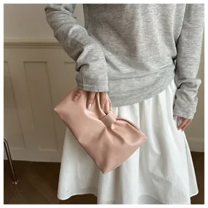 Chic pink bow clutch bag for women, elegant faux leather underarm handbag for daily commute.